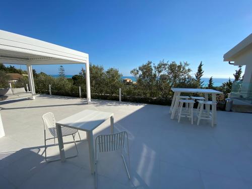 a patio with two chairs and a table and two tables at Il Mare di Giù Boutique Guesthouse in Licata