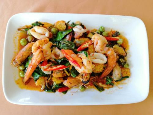 a white bowl of shrimp and vegetables on a table at Rapeepan Ville Hotel in Ubon Ratchathani