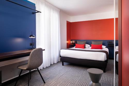 Schlafzimmer mit einem Bett mit roten und blauen Wänden in der Unterkunft Hotel Le Bugatti in Molsheim