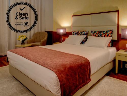 a hotel room with a large bed and a sign at VIP Executive Arts Hotel in Lisbon