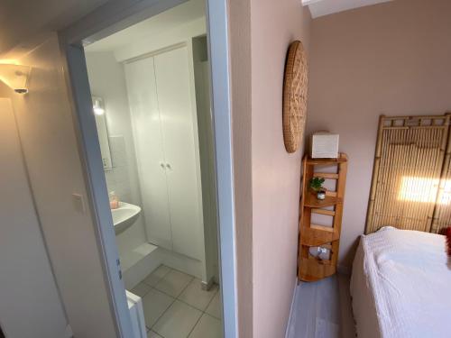 a bedroom with a bed and a bathroom with a sink at Maison de vacance proche de la mer in Les Sables-dʼOlonne