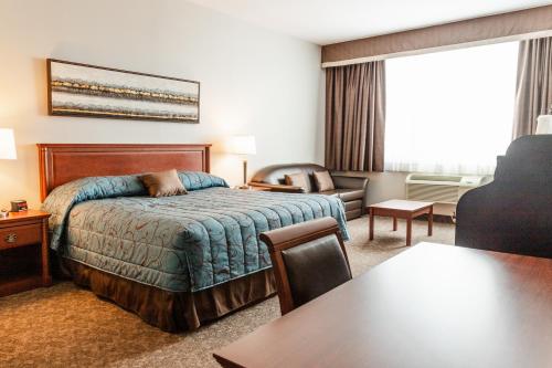 a hotel room with a bed and a living room at Adam's Airport Inn in Ottawa