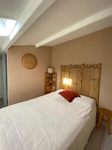 a bedroom with a large white bed and a lamp at Maison de vacance proche de la mer in Les Sables-dʼOlonne