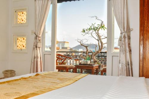 um quarto com uma cama e uma grande janela em Hue Harmony Hotel em Hue