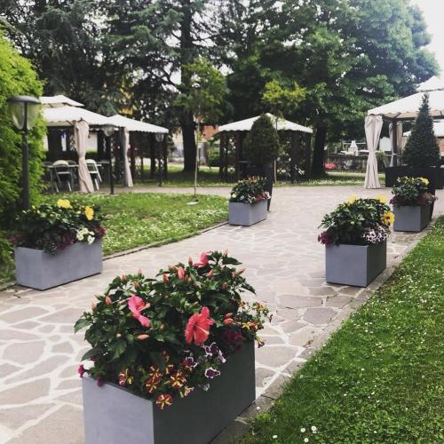a row of flowerpots with flowers in a park at Hotel Ristorante Gallo D'Oro in Vignola