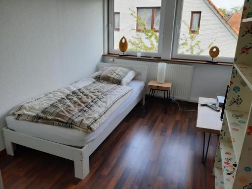 a bedroom with a bed and two windows at Bassener Monteurwohnung in Oyten