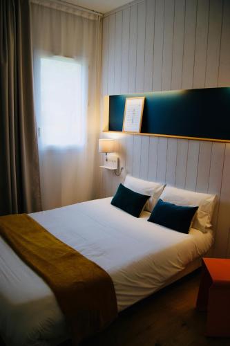 Ένα ή περισσότερα κρεβάτια σε δωμάτιο στο Logis Hôtel L'Air Marin