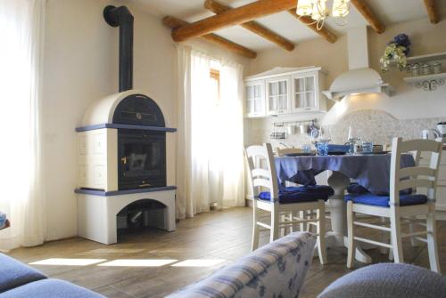 a kitchen with a stove and a table with chairs at Rustico Melograno, Il Melo - Rebomaholidays in Tignale