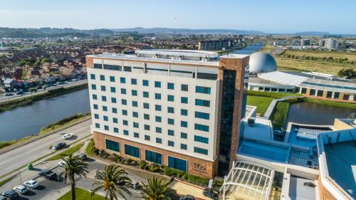 an overhead view of a large white building next to a river at MDS Hotel Concepción in Concepción