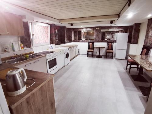 eine große Küche mit weißen Geräten und einem Tisch in der Unterkunft Hotel Destille in Dormagen