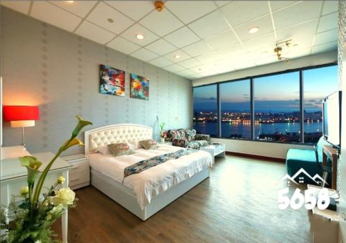 a bedroom with a bed and a large window at 85 Cape Inn in Kaohsiung