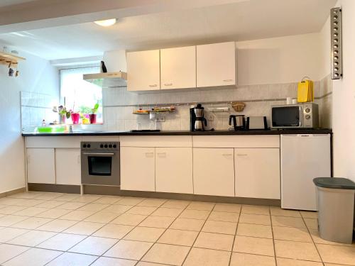 eine Küche mit weißen Schränken und einer Arbeitsplatte in der Unterkunft Ferienwohnung Fürstenwalde Spree in Ketschendorf
