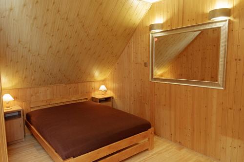 a bedroom with a bed in a wooden room at DOMKI I POKOJE -BLISKO MORZA - U Beaty - CHŁAPOWO, Władysławowo in Władysławowo