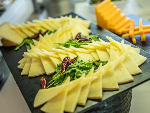 a plate of cheese and greens on a table at ON ALETA ROOM designed for adults in Almuñécar