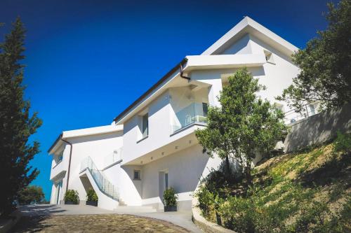 a white house on a hill with trees at Il Mare di Giù Boutique Guesthouse in Licata