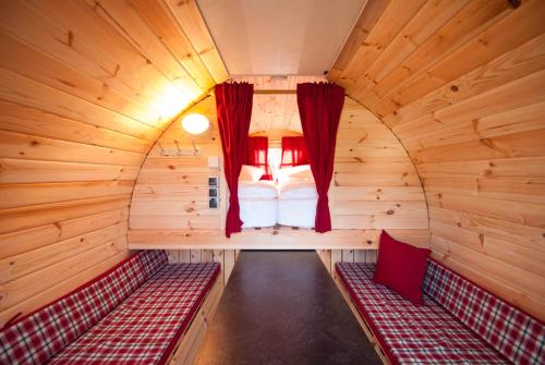 a room with a bed in a wooden cabin at Harmony beim Holzschnitzer in Dreis-Brück