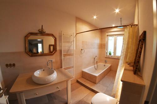 a bathroom with a sink and a tub and a mirror at Ferienwohnungen Weise im Lausitzer-Seenland in Großräschen