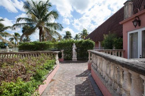 a brick walkway leading to a house with a palm tree at Miami Gardens Inn & Suites in Miami
