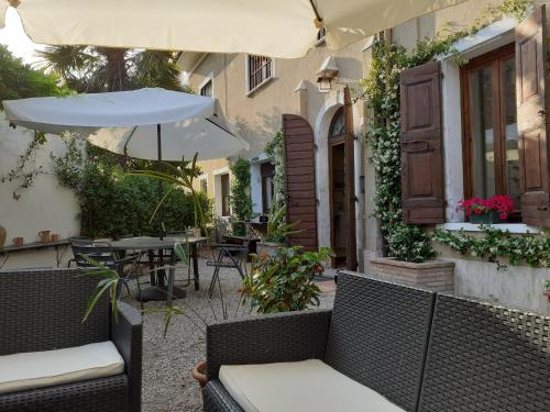 an outdoor patio with chairs and an umbrella at Residenza La Dimora ImPerfetta in Salionze