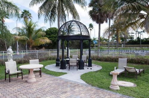 a gazebo with chairs and tables in a park at Miami Gardens Inn & Suites in Miami