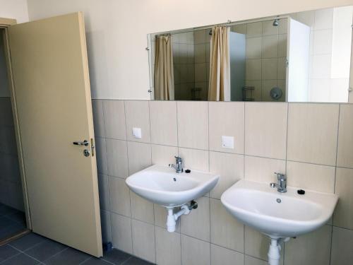 a bathroom with two sinks and a mirror at Ecohotel in Kretinga