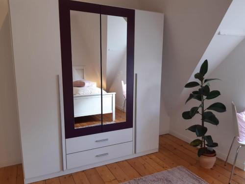 a white cabinet with a mirror in a bedroom at Cafe-Konditorei-Pension Sander in Niederfell