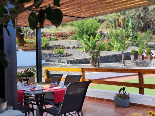 a table and chairs on a patio with a garden at Viña Camello in Buenavista del Norte