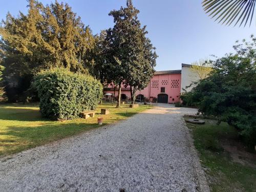 a gravel path in front of a pink building at Residenza La Dimora ImPerfetta in Salionze