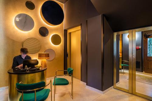 a woman sitting at a table with a laptop at SleepWell Boutique Apartments in Warsaw