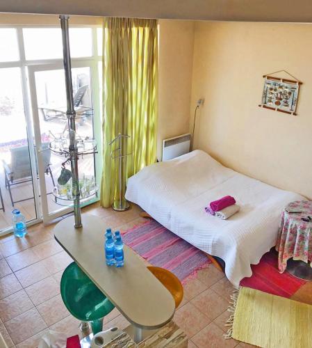 a room with a bed and a table and a window at Совиньон. Коттедж. Первая линия. in Odesa
