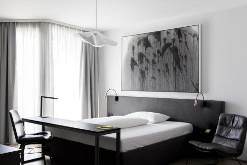 a bedroom with a bed and a desk and a chair at Lendhotel in Graz