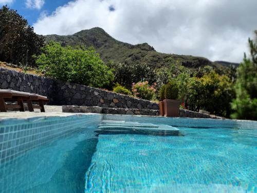 a swimming pool with a mountain in the background at Viña Camello in Buenavista del Norte