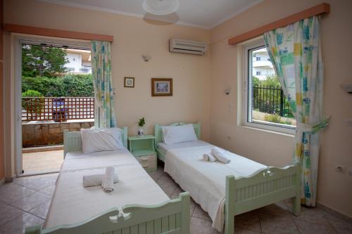 two beds in a room with a window at Eliza Apartments in Rethymno