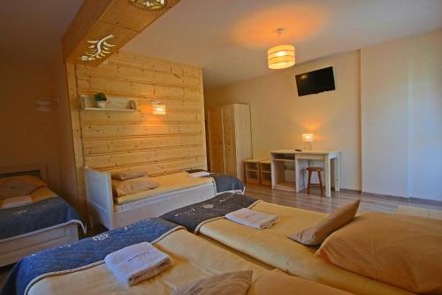 Habitación de hotel con 3 camas y mesa en Willa Pasternik en Ciche Małe