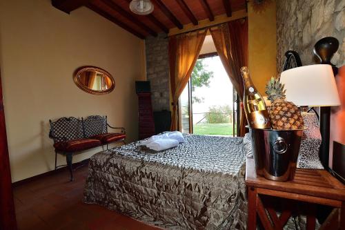 Schlafzimmer mit einem Bett und einer Flasche Champagner in der Unterkunft Country Resort Il Frassine in Rignano sullʼArno