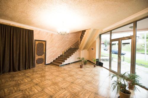 a large room with a staircase and a large window at Baron Hotel in Vanadzor