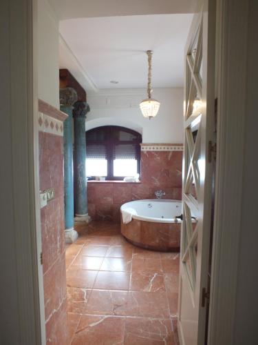a large bathroom with a tub and a window at Casa Palacio VillaZambra in Ronda