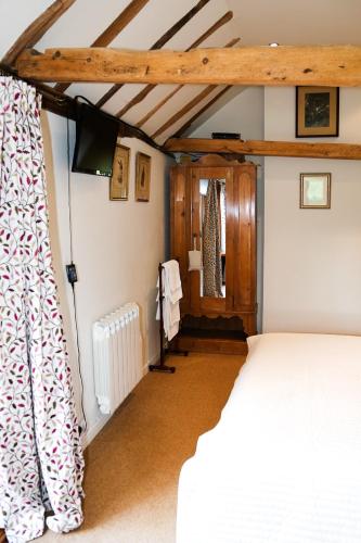 a bedroom with a bed and a curtain in a room at Wilderness B&B 3 Self Contained Rooms Nr Sissinghurst in Headcorn