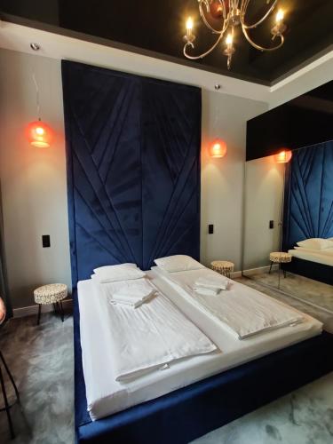 a large bed with a blue headboard in a room at Piotrkowska.eu Apartament Romantica in Łódź