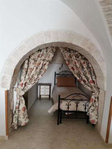 a bedroom with an archway with a bed in it at Casa Vacanza Trullo Dimora Storica Morea in Alberobello