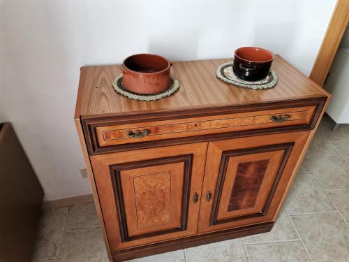 a wooden cabinet with two cups on top of it at Casa Vacanza Trullo Dimora Storica Morea in Alberobello