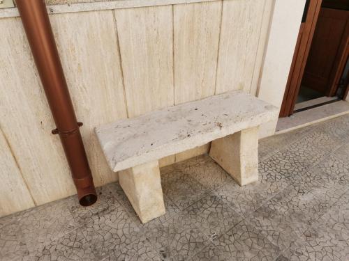 a stone bench sitting next to a wall at Casa Vacanza Trullo Dimora Storica Morea in Alberobello