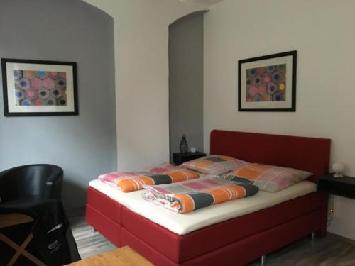 - une chambre avec un lit doté d'une tête de lit rouge dans l'établissement Ferienwohnung Mittendrin -Balkon-, à Meissen