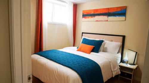 a bedroom with a bed with an orange pillow on it at Valencia Suite - 2 Bedroom basement in Jasper