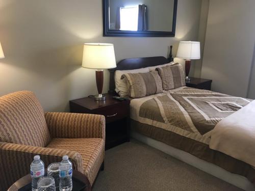 ein Hotelzimmer mit einem Bett und einem Stuhl in der Unterkunft Whitefish Corporate Residence 