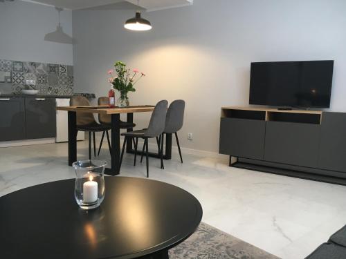 a living room with a table and a television at Apartamenty Centrum in Andrychów