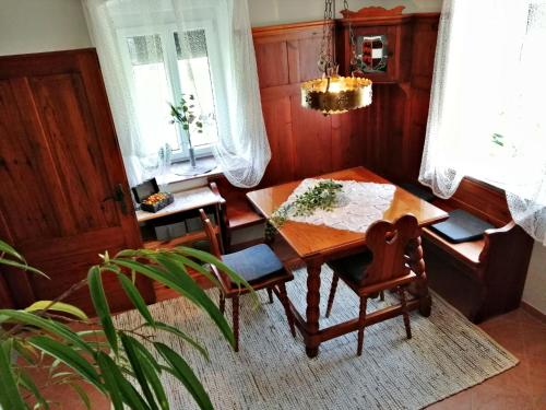 a dining room with a wooden table and a chair at Villa Komposch - adults only in Reifnitz