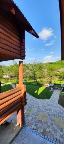a wooden bench in a park with a green field at "Карпатський краєвид" in Polyana