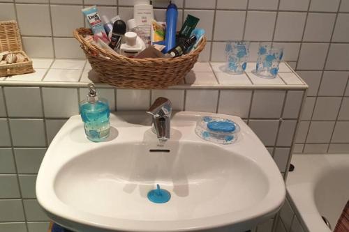 a bathroom sink with a basket on a shelf at Gemütlich in Bacharach in Bacharach