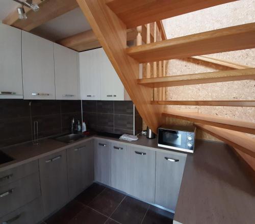 una cocina con armarios blancos y escaleras de madera en Viksvų apartamentai Juodkrantėje, en Juodkrantė